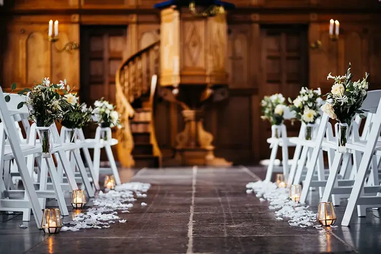 De oude kerk in Eemnes, Het Dikke Torentje, ingericht voor een trouwceremonie met witte stoelen, bloemen en kaarsjes langs het pad naar de preekstoel